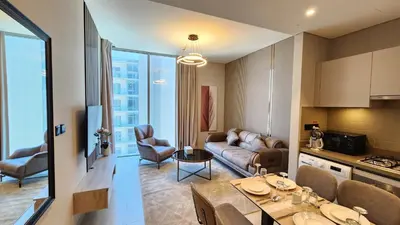 a kitchen and a living room with a couch and a table at STAY BY LATINEM Luxury 1BR Holiday Home CVR A3001 near Burj Khalifa in Dubai
