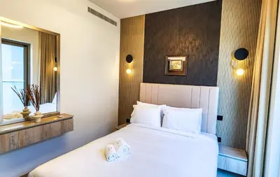 a bedroom with a white bed and a mirror at STAY BY LATINEM Luxury 1BR Holiday Home CVR A3001 near Burj Khalifa in Dubai