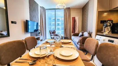 a dining room with a table and a living room at STAY BY LATINEM Luxury 1BR Holiday Home CVR A3001 near Burj Khalifa in Dubai