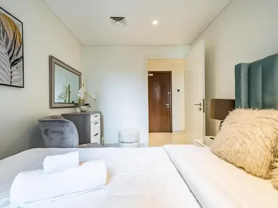 a bedroom with a large white bed with white sheets at Charming 2Br in Boulevard Crescent - Downtown Dubai in Dubai