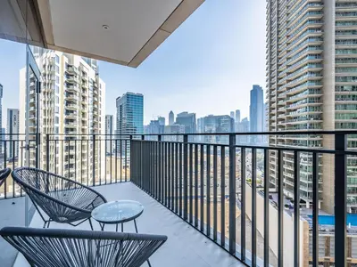 a balcony with two chairs and a table and a city at Charming 2Br in Boulevard Crescent - Downtown Dubai in Dubai