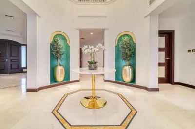 a lobby with a table and two vases with flowers at Frond E Villa, Palm Jumeirah - Mint Stay in Dubai