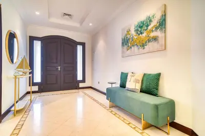 a living room with a green couch and a door at Frond E Villa, Palm Jumeirah - Mint Stay in Dubai