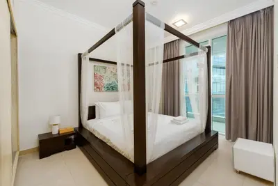 a bedroom with a canopy bed with a window at Al Bateen Residences, Jumeirah Beach Residence - Mint Stay in Dubai