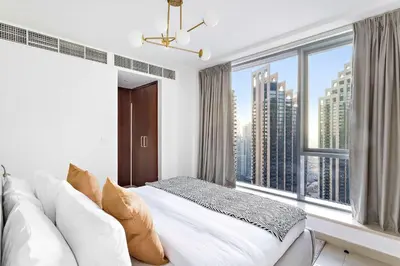 a bedroom with a white couch and a large window at Silkhaus with Burj Khalifa view1BDR with modern amenities in Dubai