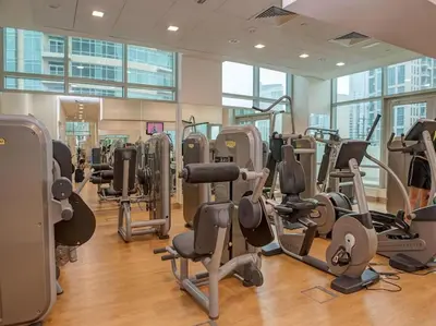 a gym with lots of treadmills and elliptical machines at The Lofts, Downtown Dubai - Bright One Bedroom in Dubai