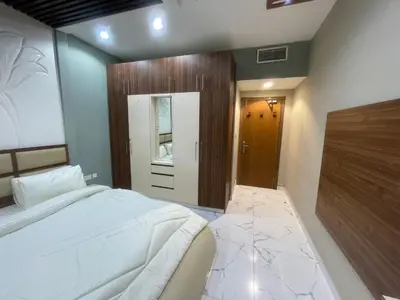 a bedroom with a white bed and a wooden door at Sea View Apartments Marina with Party Hall in Dubai