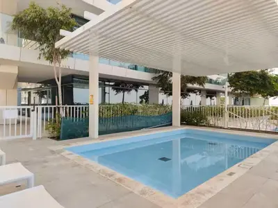 a swimming pool in front of a building at Vogue Emaar Beachfront Beach Vista near JBR and Palm Jumeirah, One Bedroom Apartment with Balcony and Private Beach, Access to all Amenities in Dubai