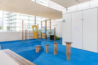 a childrens playground with benches and a slide at Vogue Emaar Beachfront Beach Vista near JBR and Palm Jumeirah, One Bedroom Apartment with Balcony and Private Beach, Access to all Amenities in Dubai
