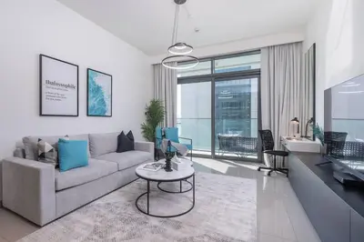 a living room with a couch and a table at Vogue Emaar Beachfront Beach Vista near JBR and Palm Jumeirah, One Bedroom Apartment with Balcony and Private Beach, Access to all Amenities in Dubai
