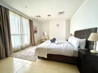 a bedroom with a large bed and a large window at JBR Sea View 2 Bedroom Apartment in Dubai
