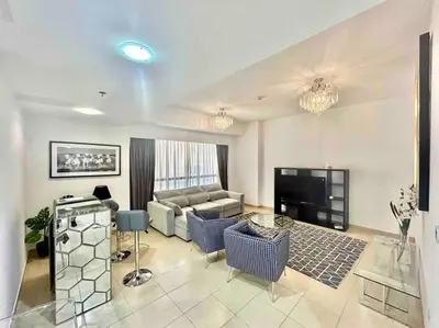 a living room with a couch and a tv at JBR Sea View 2 Bedroom Apartment in Dubai