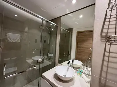 a bathroom with two sinks and a glass shower at Beautiful Studio Apartment in Dubai Marina in Dubai