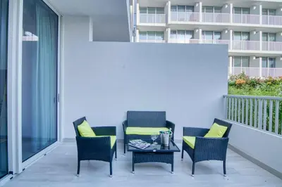 a patio with two chairs and a table on a balcony at The Smart Concierge - Luma 21 in Dubai