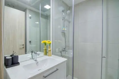 a bathroom with a sink and a glass shower at The Smart Concierge - Luma 21 in Dubai