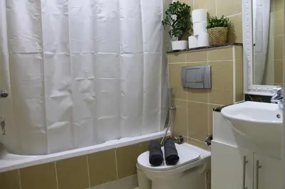 a bathroom with a toilet with a pair of shoes on it at Newly furnished cozy 1 bedroom apartment close to JBR beach and metro in Dubai