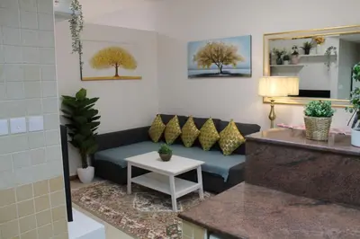 a living room with a couch and a table at Newly furnished cozy 1 bedroom apartment close to JBR beach and metro in Dubai