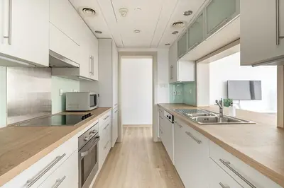a large kitchen with white cabinets and a sink at Frank Porter - Burj Views Tower A in Dubai