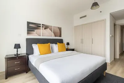 a bedroom with a large white bed with yellow pillows at Frank Porter - Burj Views Tower A in Dubai