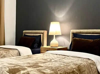 a bedroom with two beds and a lamp on a table at Chic 3 bedroom apartment in Dubai