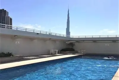 a bridge over a swimming pool with blue water at Chic 3 bedroom apartment in Dubai