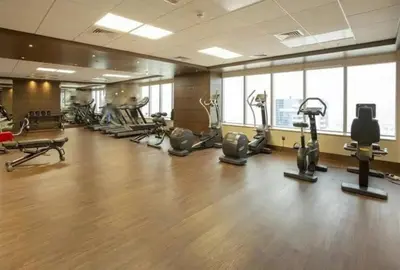 a gym with several treadmills and exercise bikes at Chic 3 bedroom apartment in Dubai