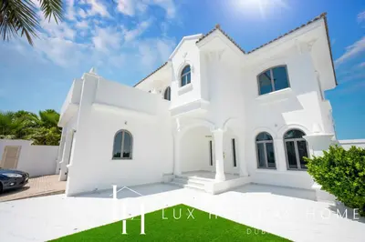 a white villa with a lawn in front of it at LUX The Ultimate Island Palm Villa in Dubai