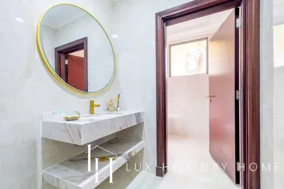 a bathroom with a sink and a mirror at LUX The Ultimate Island Palm Villa in Dubai