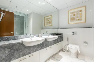 a bathroom with two sinks and a toilet at Lux BnB I Amna Tower I Panaromic Views in Dubai