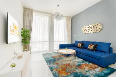a living room with a blue couch and a table at Lux BnB I Amna Tower I Panaromic Views in Dubai