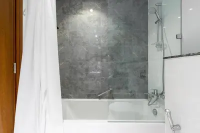 a bathroom with a shower and a bath tub at Lux BnB I Amna Tower I Panaromic Views in Dubai