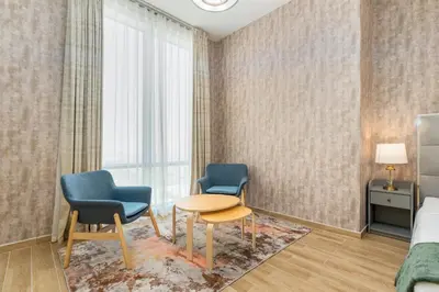 a hotel room with two chairs and a table and a bed at Lux BnB I Amna Tower I Panaromic Views in Dubai
