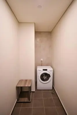 a laundry room with a washing machine and a table at Vera Residence with Canal View in Dubai