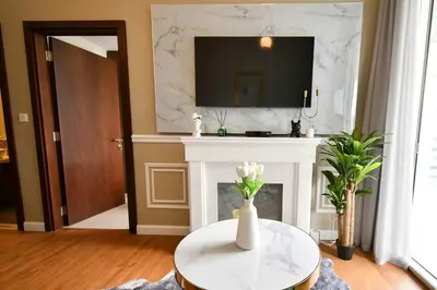 a living room with a fireplace and a white table at Vera Residence with Canal View in Dubai