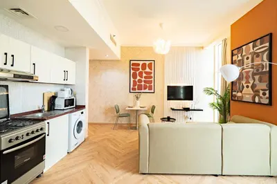 a living room with a couch and a kitchen at Scala Tower Central Chic with a twist studio in Dubai