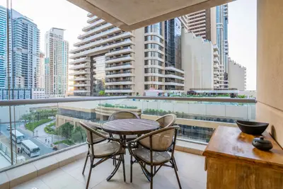 a balcony with a table and chairs and a view of a city at Vacay Lettings- Stylish waterfront getaway home in Dubai