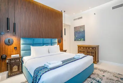 a bedroom with a large bed with a blue headboard at Vacay Lettings- Stylish waterfront getaway home in Dubai