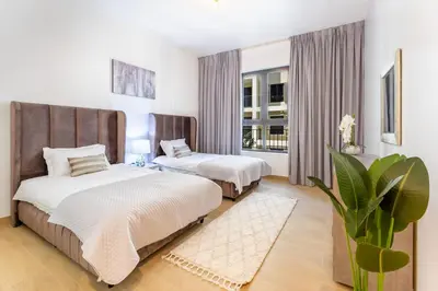 a bedroom with two beds and a large window at Stunning 2BR Apartment in Port De La Mer in Dubai