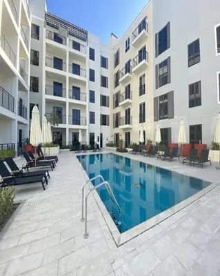 a pool in the courtyard of a apartment building at Stunning 2BR Apartment in Port De La Mer in Dubai