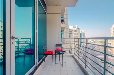 a balcony with two chairs and a table at Icon Delux Hotel Apartments Al Barsha - Formerly Abidos in Dubai