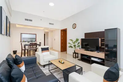 a living room with a couch and a tv at 1bd apt plus study I Close to mall I Fast wi-fi in Dubai