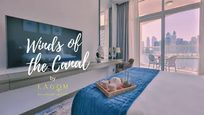 a bedroom with a bed with a tv on the wall at Winds of the Canal by Lagom - Business Bay Dubai in Dubai