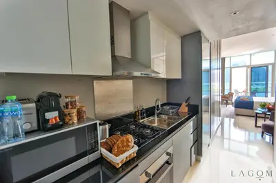 a kitchen with a sink and a stove top oven at Winds of the Canal by Lagom - Business Bay Dubai in Dubai