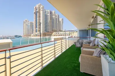 a balcony with chairs and a view of the city at 2 Bedroom App with private beach and infinity pool in Dubai