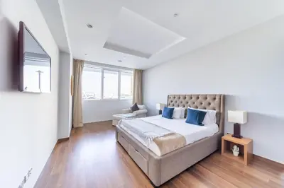 a bedroom with a large bed with blue pillows at 2 Bedroom App with private beach and infinity pool in Dubai