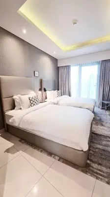 a bedroom with two beds and a large window at Luxury apartment Paramount Hotel A21 in Dubai