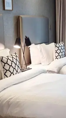 a bedroom with two beds with white sheets and a lamp at Luxury apartment Paramount Hotel A21 in Dubai
