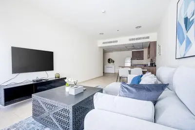 a living room with a white couch and a tv at High Floor Elegance,Prime Location-Close to tram in Dubai