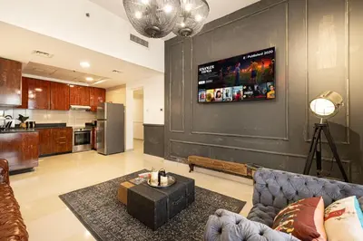 a living room with a couch and a tv on a wall at Beautiful home, Magnificent view in Dubai