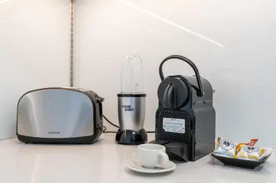 a toaster and a toaster and a coffee maker on a counter at Very Cozy & Relaxing Studio in JVC in Dubai